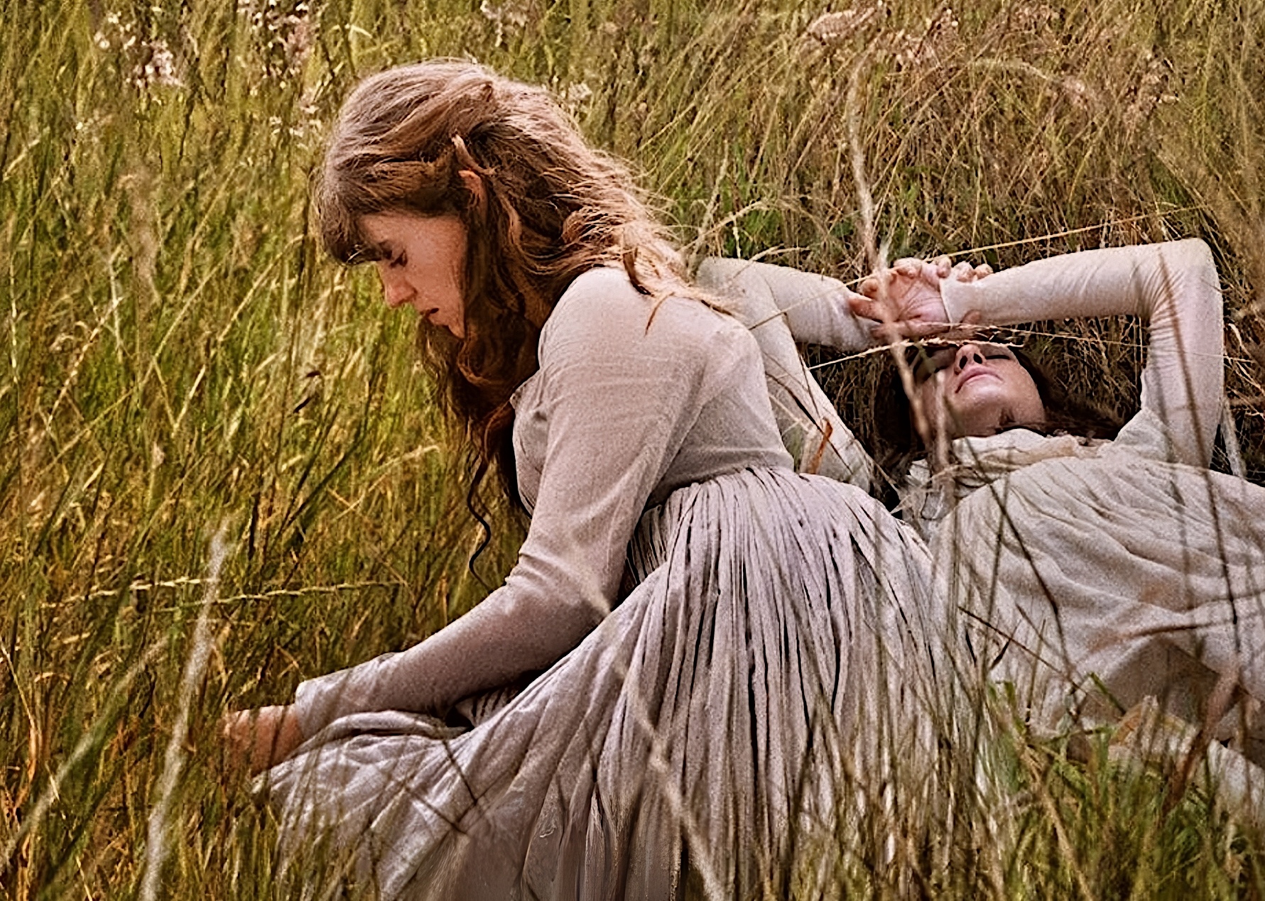 Esme Creed-Miles, Daisy Edgar Jones laying in grass in Sense and Sensibility